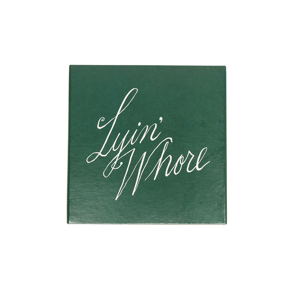 Green card with 'Lyin' Whore' in white cursive text on a white background