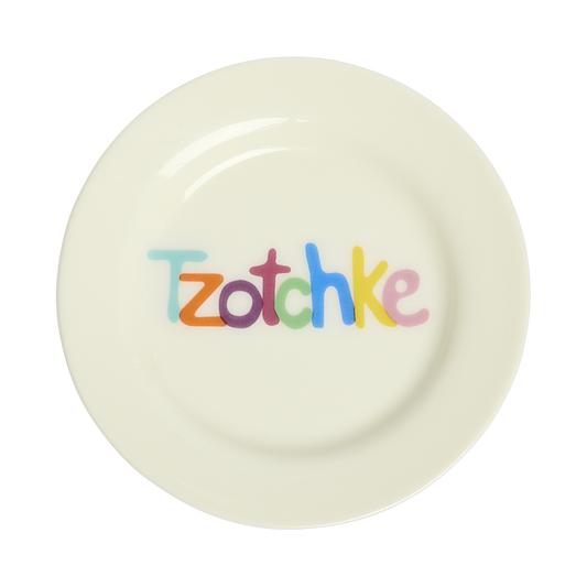 White ceramic plate with colorful text 'Tzotchke' on a white background